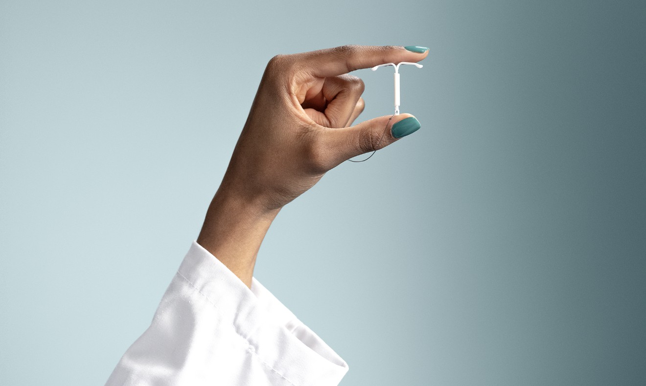 Hand holding Mirena IUD A hand holding a Mirena (levonorgestrel-releasing intrauterine system) 52mg IUD between thumb and index fingers